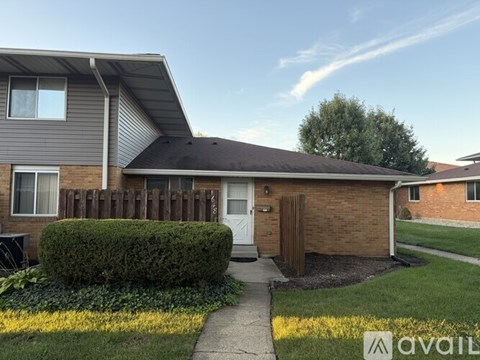 A house with a white door and a brown fence.