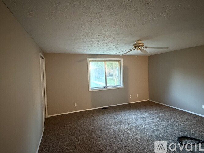 A room with a ceiling fan and a window.
