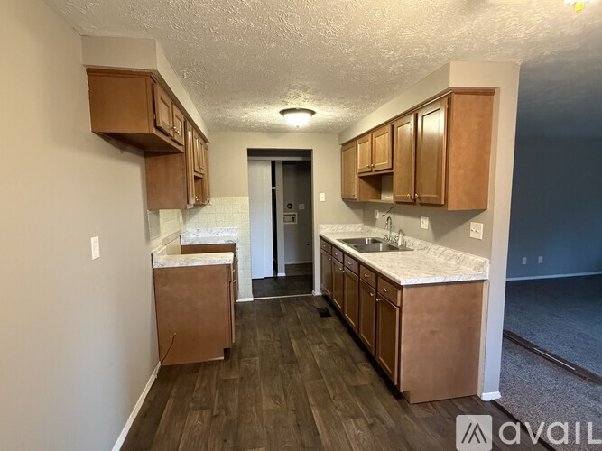 A kitchen with wooden cabinets and a white countertop is available for rent.