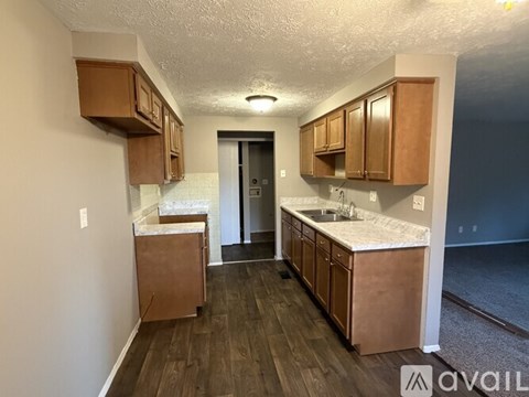 A kitchen with wooden cabinets and a white countertop is available for rent.