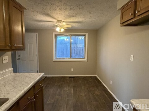 A kitchen with wooden cabinets and a marble countertop.