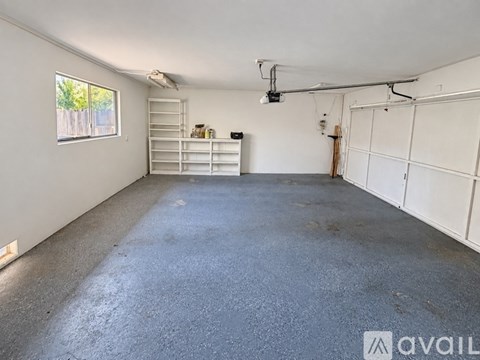 A spacious garage with a concrete floor and white walls.