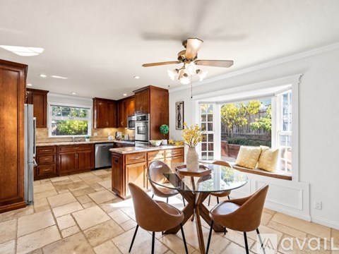 A kitchen with a table and chairs in front of a window.
