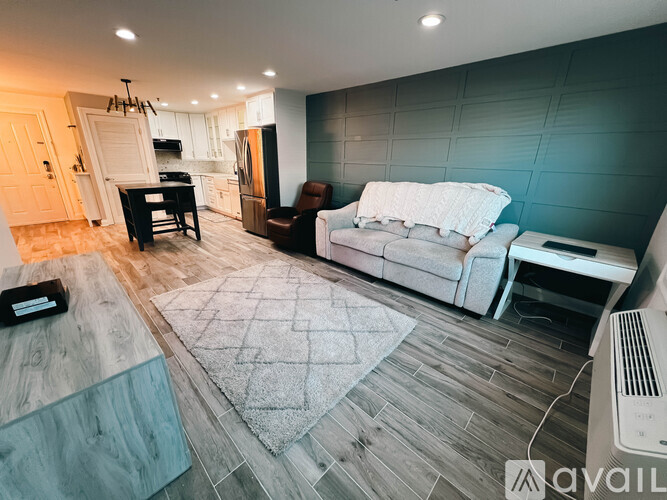 A living room with a couch, chair, and a dining table.