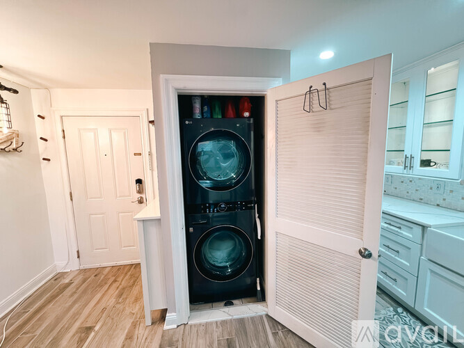 A black washing machine is in a white door.
