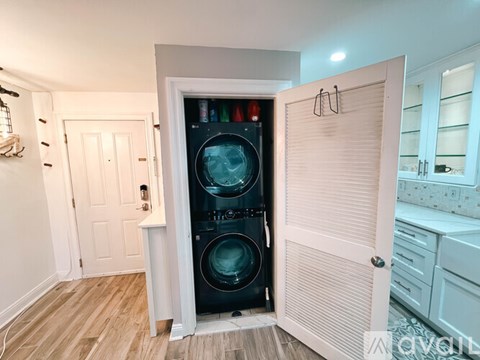 A black washing machine is in a white door.