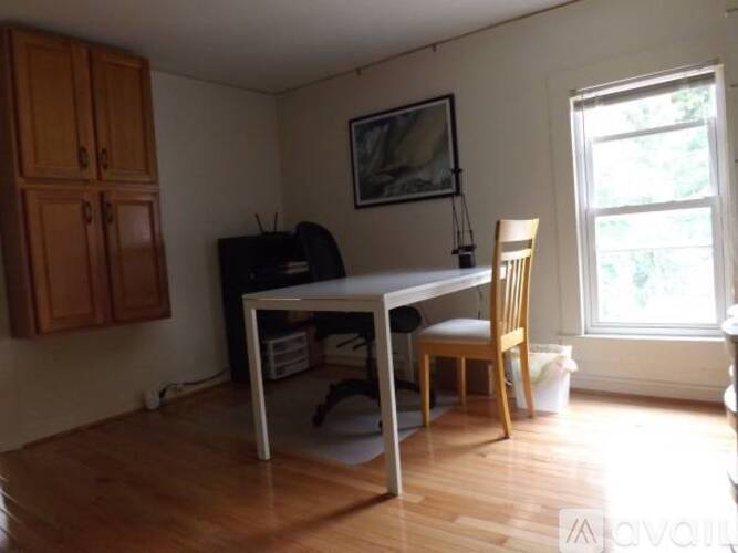 A room with a desk, chair, and a cabinet.