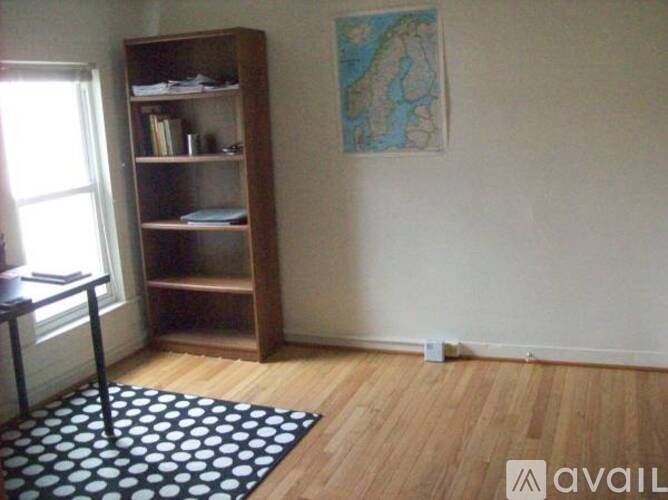 A room with a bookshelf and a map on the wall.