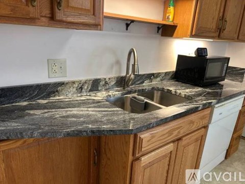 A kitchen counter with a sink and a microwave on it.