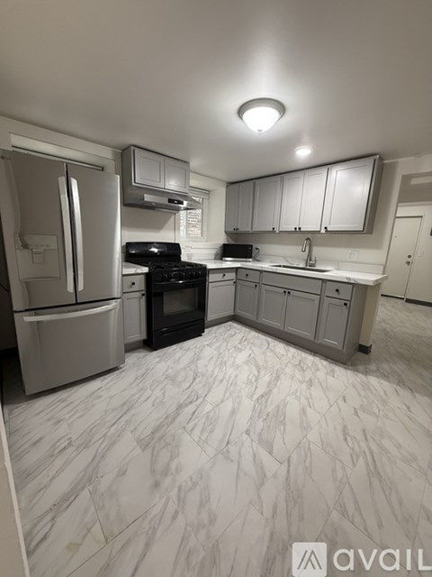 A kitchen with a black oven and a fridge.