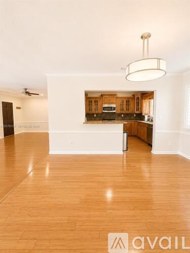 A spacious kitchen with wooden cabinets and a white island.
