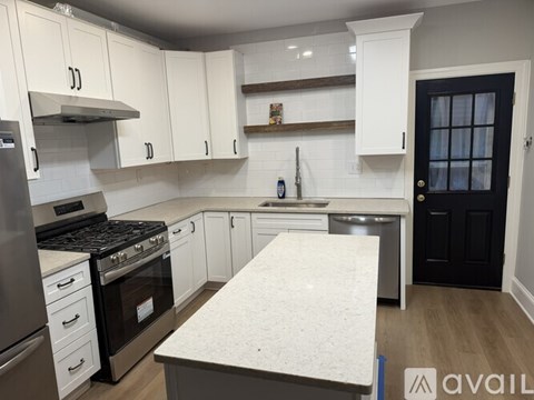A kitchen with white cabinets and a marble countertop.