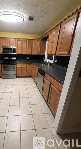A kitchen with wooden cabinets and black countertops.