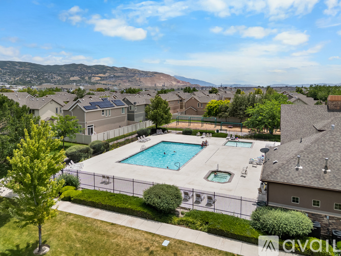 A pool surrounded by a fence and a mountain in the background.