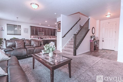 A living room with a brown leather couch and a coffee table.