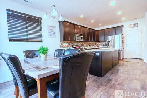 A kitchen with brown cabinets and a dining table with chairs.