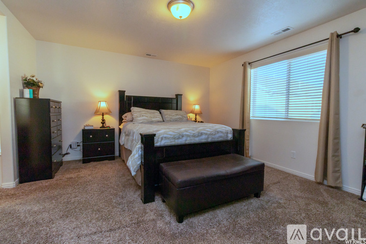 A bedroom with a bed, nightstand, and chair.