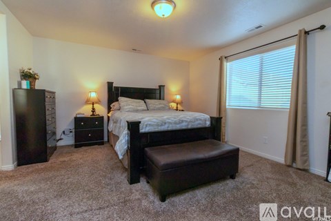 A bedroom with a bed, nightstand, and chair.