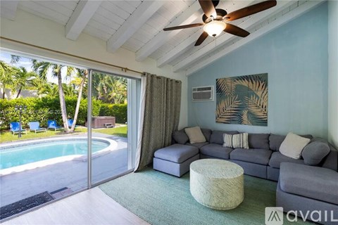 A living room with a grey couch and a ceiling fan.