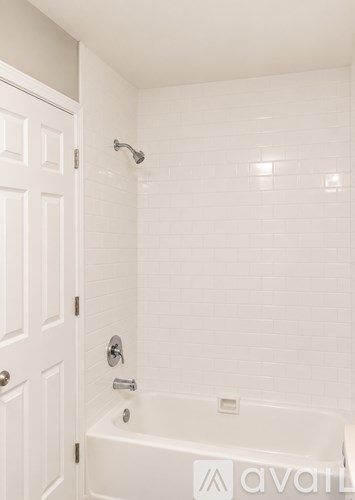 A white bathroom with a tub and a door.