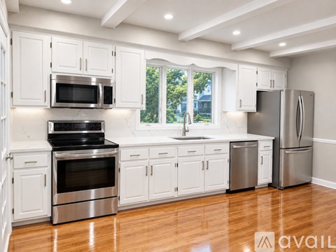 A kitchen with white cabinets and stainless steel appliances.