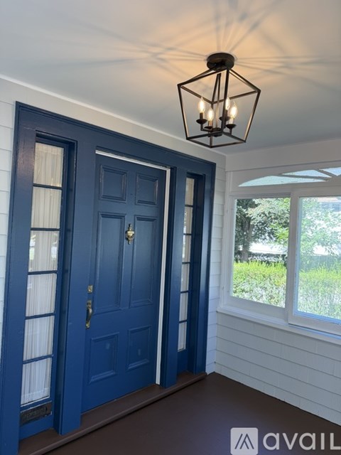 A blue door with a glass window and a white wall.