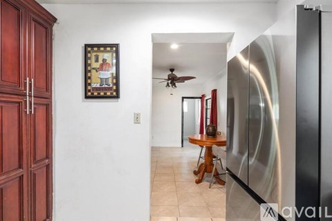 A kitchen with a wooden table and a fridge.