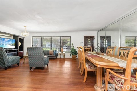 A dining room with a wooden table and chairs.