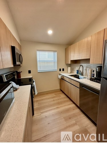 A kitchen with wooden cabinets and a black refrigerator.