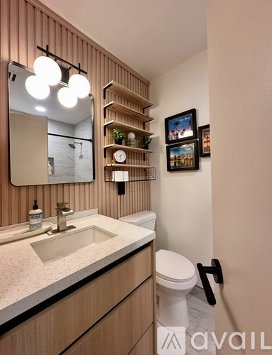 A bathroom with a sink, toilet, and a mirror.