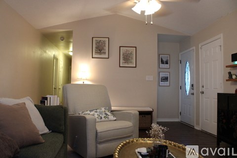 A living room with a grey couch and a green chair.