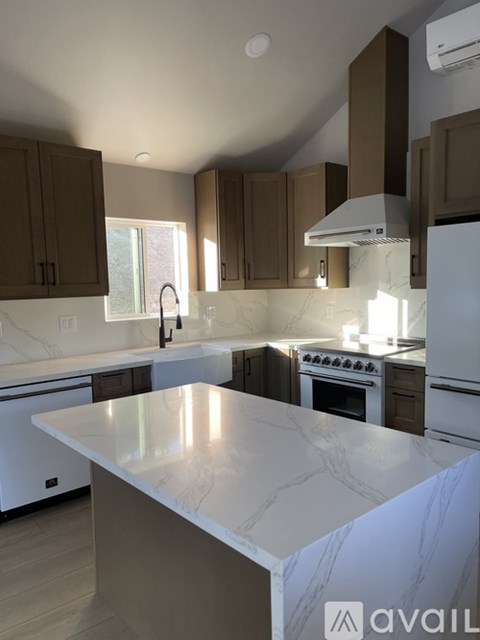 A kitchen with a marble countertop and white appliances.