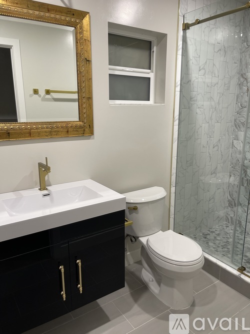 A bathroom with a toilet, sink, and mirror.