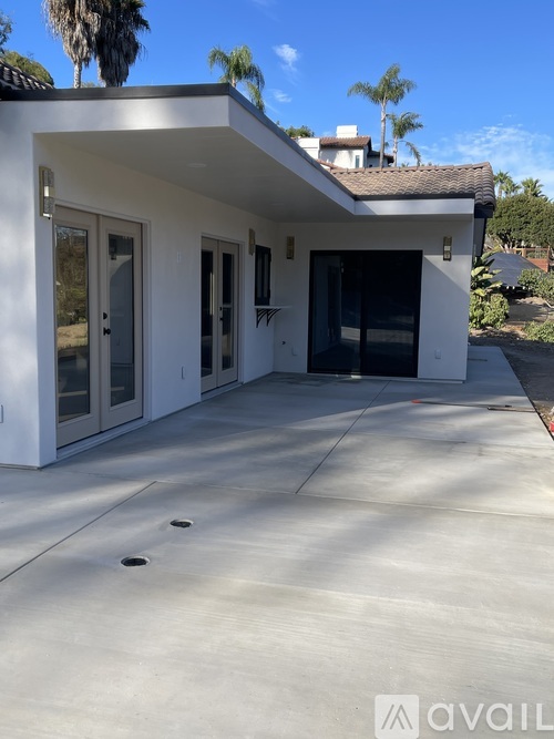 A modern house with a white exterior and a large patio area.