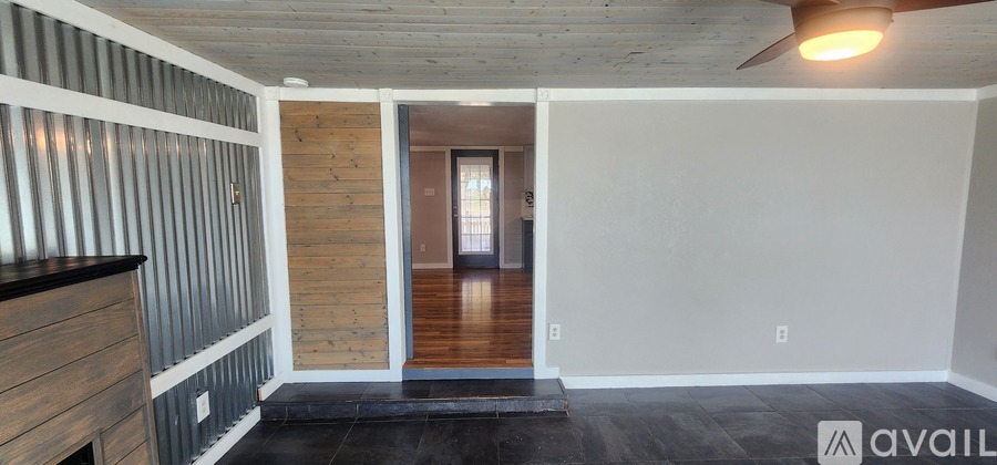 A room with wooden walls and a black floor mat.
