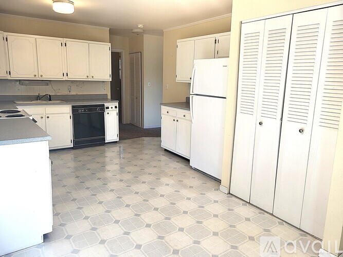 A kitchen with white appliances and cabinets.