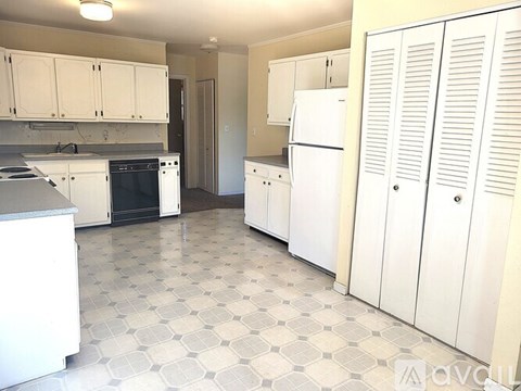 A kitchen with white appliances and cabinets.
