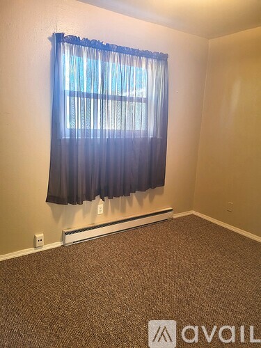 A room with a window covered by a blue curtain.