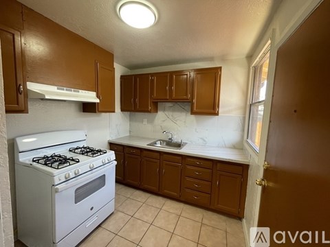 A kitchen with a white stove and brown cabinets.