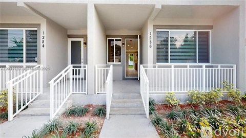A white building with a balcony and a door.