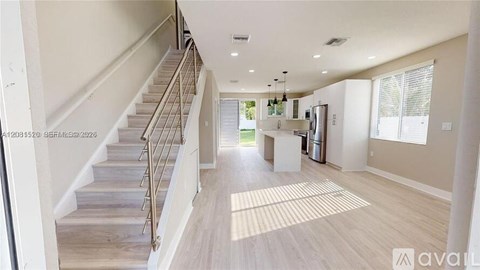 A spacious living room with a staircase leading to the upper floor.
