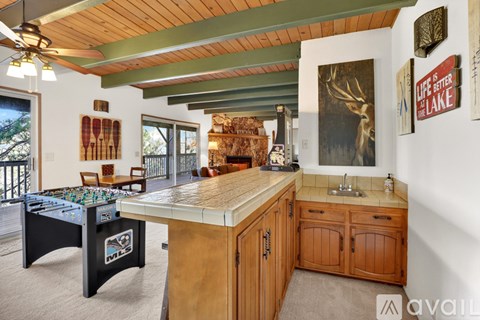 A room with a pool table and a wooden cabinet.