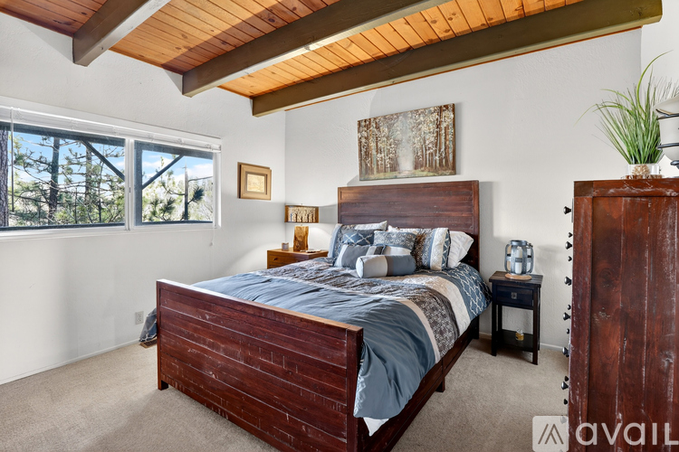 A bedroom with a large bed and a wooden headboard.