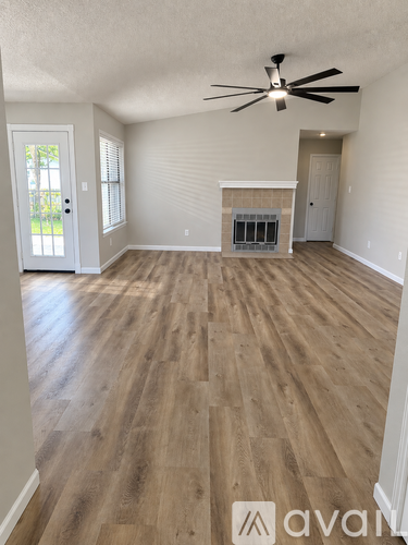 A room with wooden flooring and a ceiling fan.