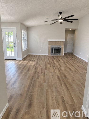 A room with wooden flooring and a ceiling fan.