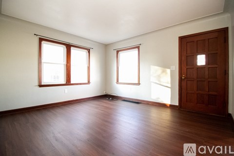 A room with wooden floors and a brown door.