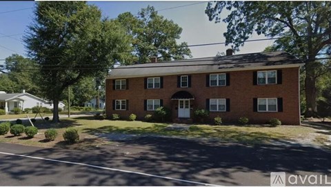 A red brick house with a white door and windows is for sale.
