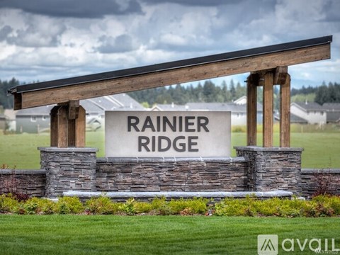 A sign that says Rainier Ridge stands in front of a grassy field.
