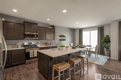 A modern kitchen with dark brown cabinets and a white island.