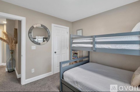 A bedroom with a bunk bed and a mirror on the wall.